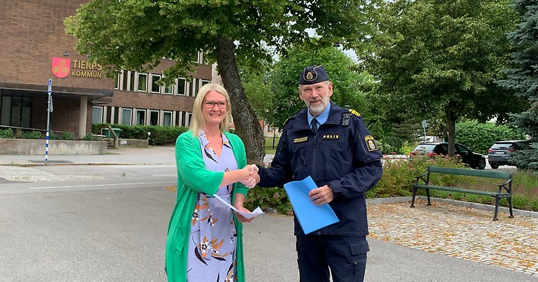 Kommunstyrelsens ordförande Sara Sjödal (C) skakar hand med Tomas Eriksson vid lokalpolisen i Norduppland.