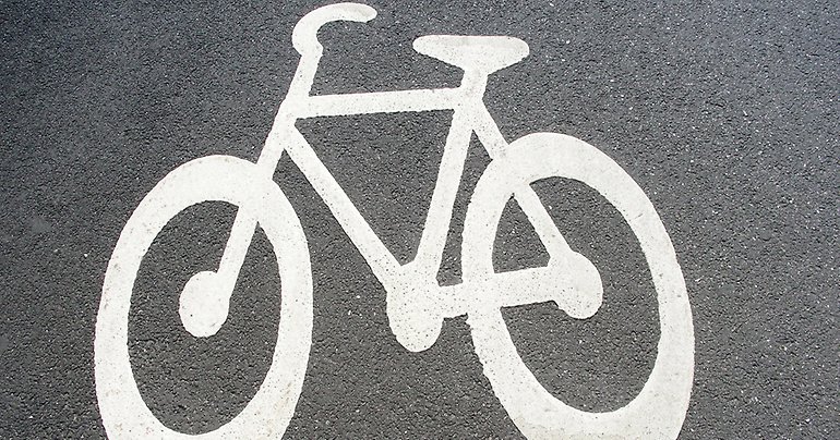 Illustrerad cykel på asfalten av en cykelbana